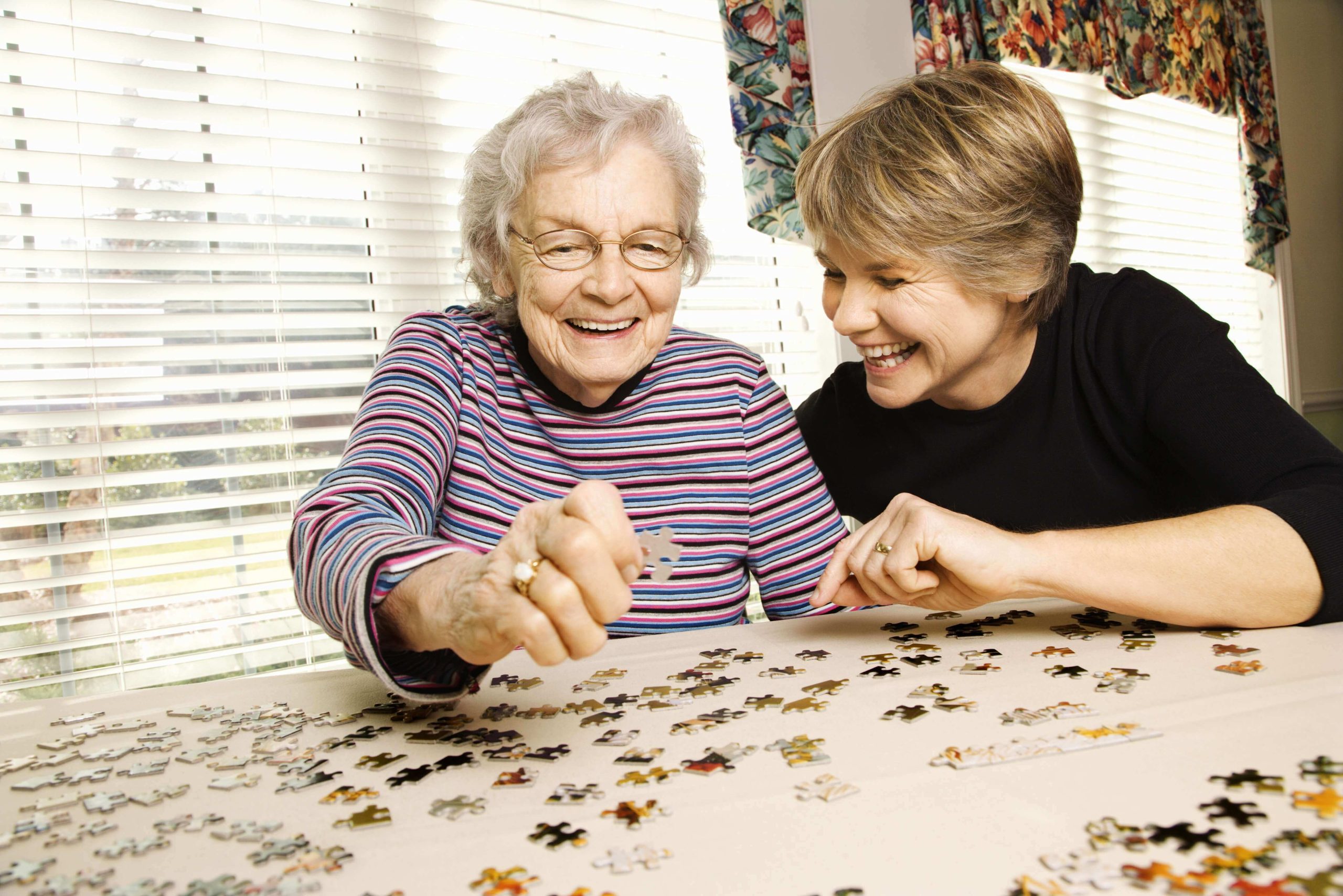 Elderly Woman and Younger Woman Doing Puzzle