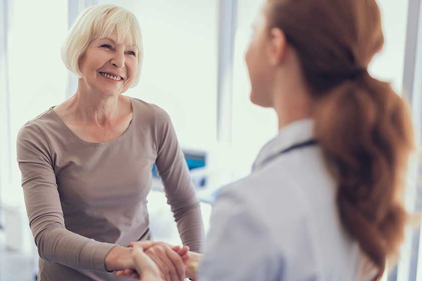 Happy aged woman is thanking doctor for care