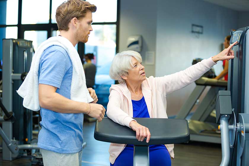 Senior woman working out with personal trainer