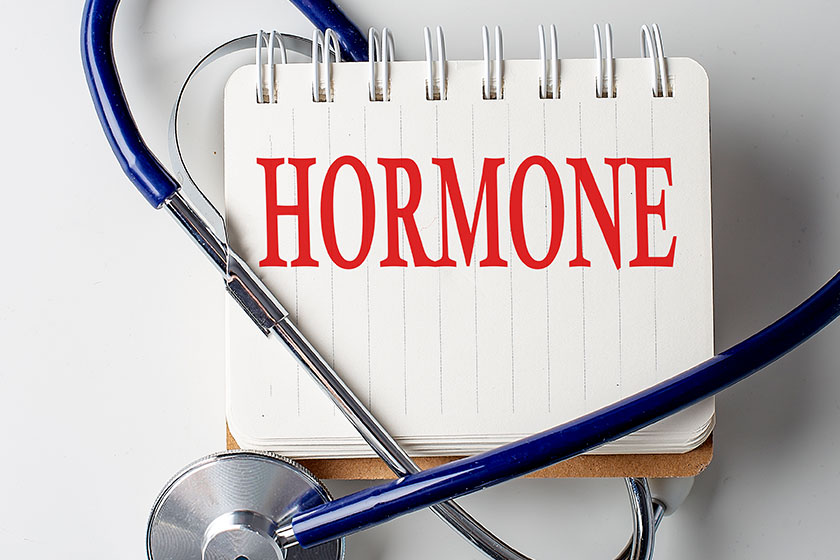 HORMONE word on a notebook with medical equipment background