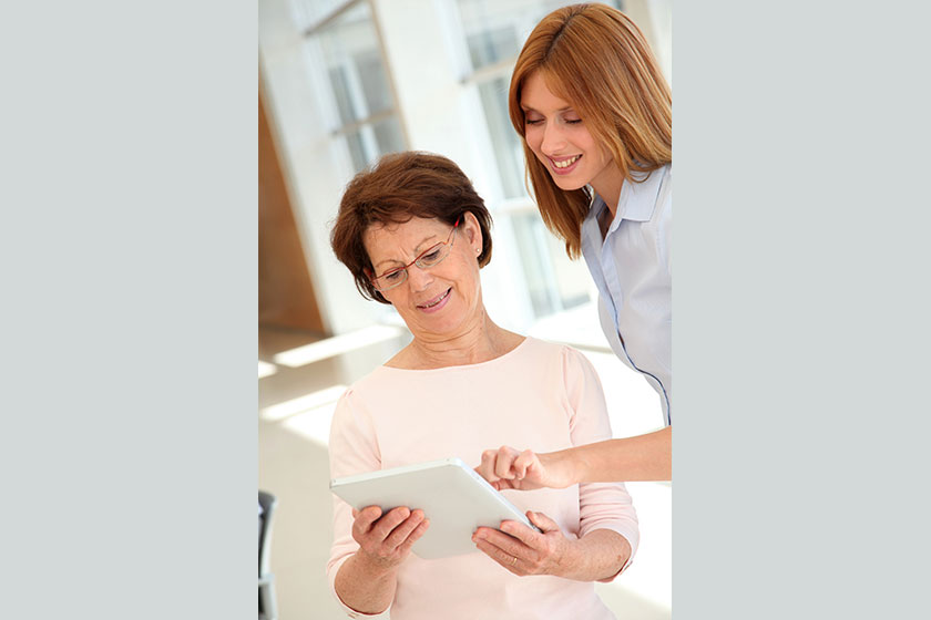 Senior woman learning how to use electronic tablet