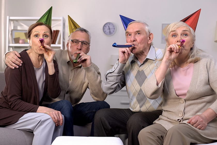 cheerful-aged-people-birthday-hats-blowing-party-horns