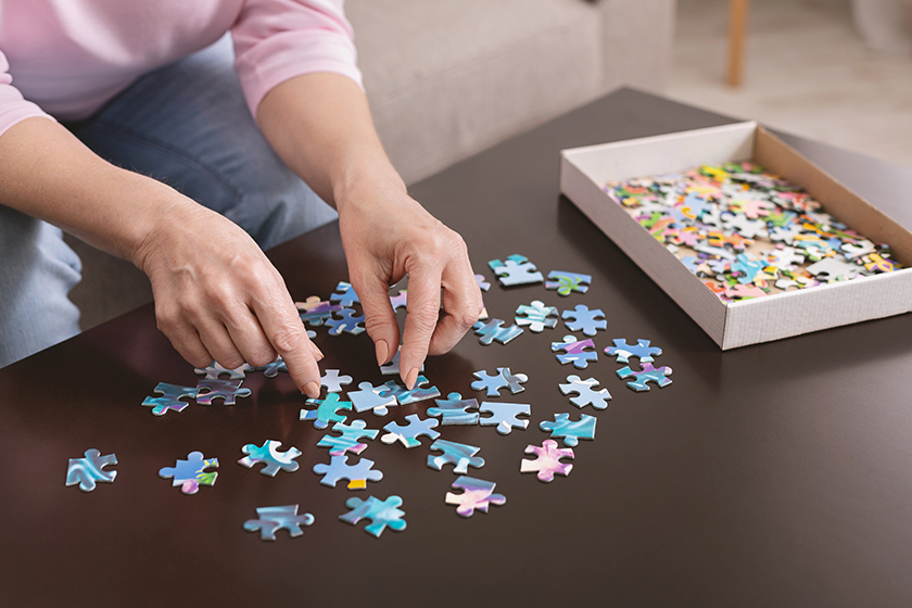 elderly-woman-hands-doing-jigsaw-puzzle