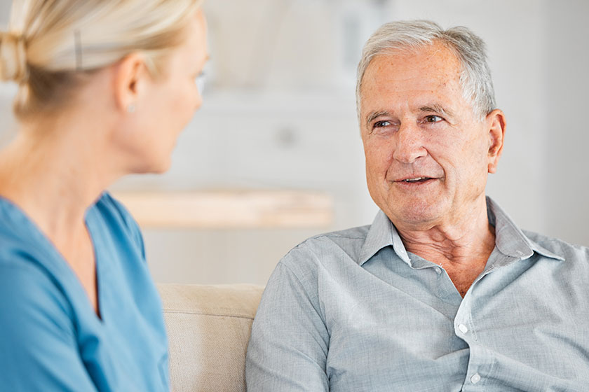 A nurse caring for a senior man at home.